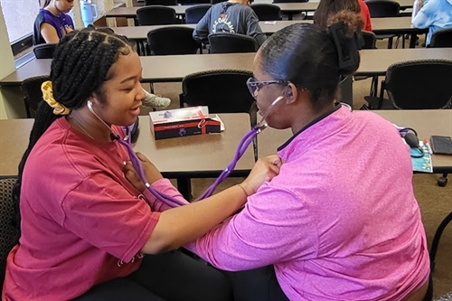 Oklahoma high school students listening to each other’s heartbeats.